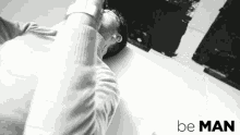 a black and white photo of a man with the words be man written on the bottom