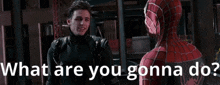 a man in a spiderman suit is talking to another man in a leather jacket .