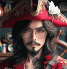 a man with long hair and a beard is wearing a pirate hat and sunglasses .