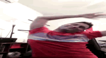 a man in a red shirt is standing upside down in a room