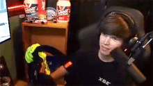 a boy wearing headphones is sitting in front of a microphone in a room .
