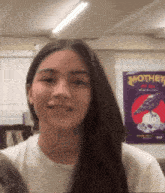 a woman with long hair is smiling in front of a poster that says mother of all