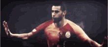 a soccer player with the number 14 on his back is kneeling down on the field .