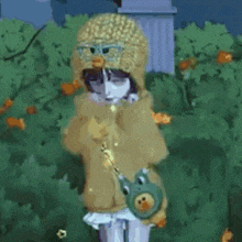 a girl wearing a hat and glasses is holding a stuffed duck and a frog purse .