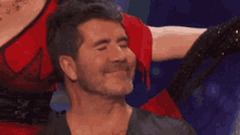 a woman is touching a man 's face with her hand while he is smiling .