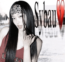 a woman wearing a leopard print headband stands in front of a sign that says sybeau