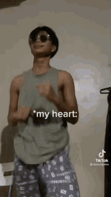 a young man wearing sunglasses and pajamas is dancing in a room .
