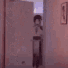 a blurry picture of a person standing in a hallway with a cat .