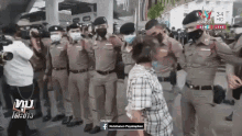 a group of police officers wearing face masks are standing in front of a woman