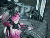 a woman in a pink suit is standing in a room holding a gun