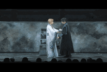 a man and a woman are standing on a stage and holding hands