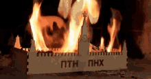 a model of a building is burning in a fireplace with the word phx written on it