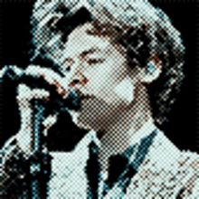 a man in a suit and tie singing into a microphone