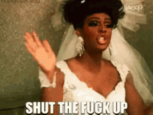 a drag queen in a wedding dress is saying shut the fuck up .