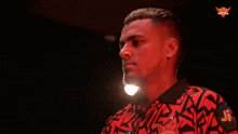 a man wearing a red and black shirt with jr on the sleeve