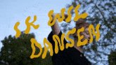 a person is standing in front of a sign that says srk will dansen