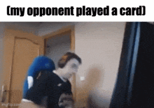 a man is sitting in front of a computer screen with the words my opponent played a card .