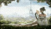 a woman in a white dress is holding a fan and looking at the eiffel tower