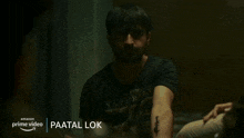 a man in a police uniform is talking to another man in a dark room with the name paatal lok on the bottom