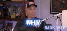 a man in a hat is sitting in front of a microphone with the words why dark web behind him .