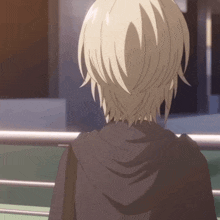 a person with short blonde hair is wearing a black hooded jacket