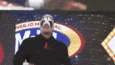 a man in a mask is standing in front of a sign that says consejo mundial