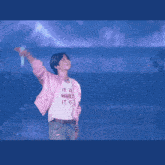 a man in a pink shirt stands on a stage