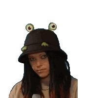 a woman wearing a frog hat with frog ears on it .