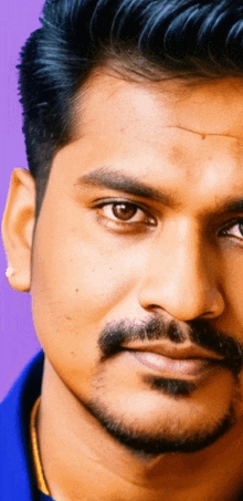 a close up of a man 's face with a blue shirt