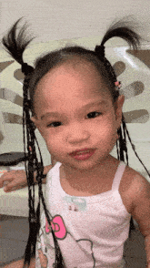 a little girl wearing a hello kitty tank top looks at the camera