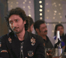 a man wearing a black jacket with a tiger on the sleeve