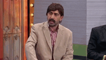 a man with a mustache is wearing a suit and striped shirt
