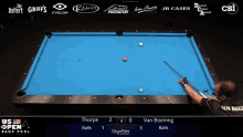 a pool table with a blue cloth and a man playing pool