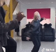 a woman is dancing in a room with a tiktok watermark
