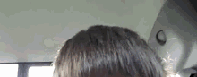 a close up of a person 's head and hair in a car .
