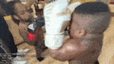 a man is wearing boxing gloves and holding a baby in his arms .