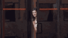 a person is standing in front of a glass door with a green sign on it .