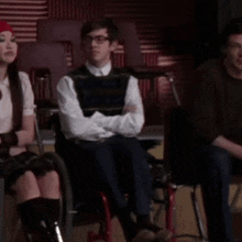 a group of people are sitting in chairs in a classroom .