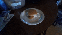 a white plate with a sandwich on it that looks like a chicken bone