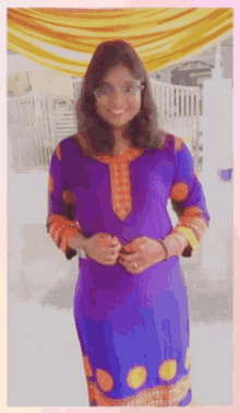 a woman in a purple and orange dress is smiling for the camera