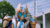 a purple and blue ice cream cone costume with wings is standing in front of a building
