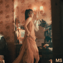 a woman in a long dress is dancing in a room with the word ms on the bottom