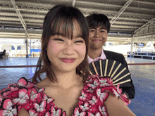 a boy and a girl are posing for a picture and the girl is wearing a pink dress with butterflies on the sleeves