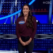 a woman is standing on a stage with her hands folded and a name tag that says shyanne .