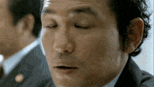 a close up of a man 's face with his eyes closed and his mouth open