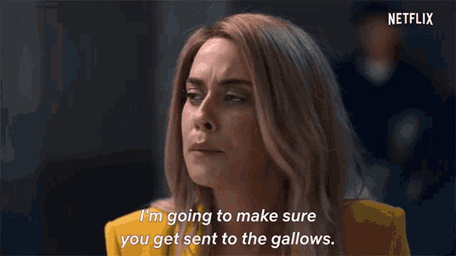 a woman in a yellow jacket says i 'm going to make sure you get sent to the gallows .