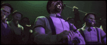 a man in a bow tie and suspenders stands in a crowd of men