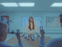 a man takes a picture of a girl in front of an emergency exit sign
