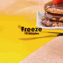 a person is cutting a stack of cookies with chocolate sauce and a strawberry on top