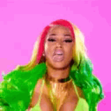 a woman with red hair and green hair is wearing a green jacket and a green top .